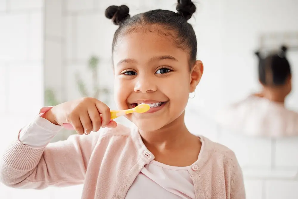 Young girl brushing her teeth in a bathroom at home