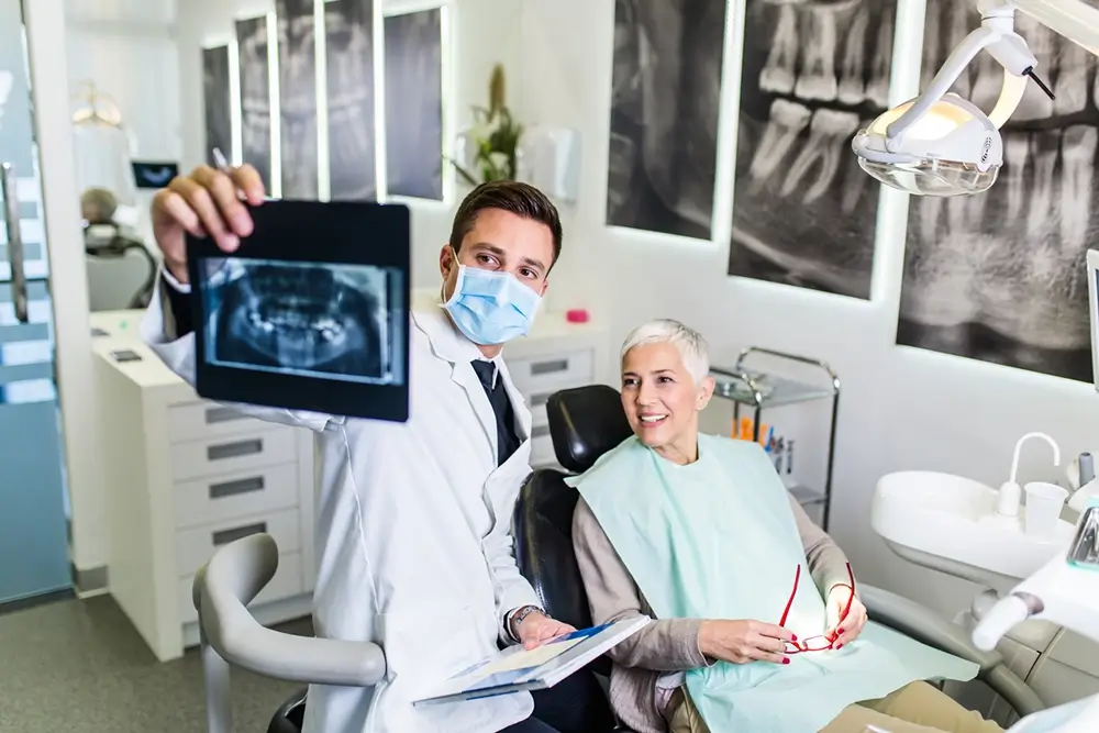Dentist checking x-ray image while woman recieves a dental treatment